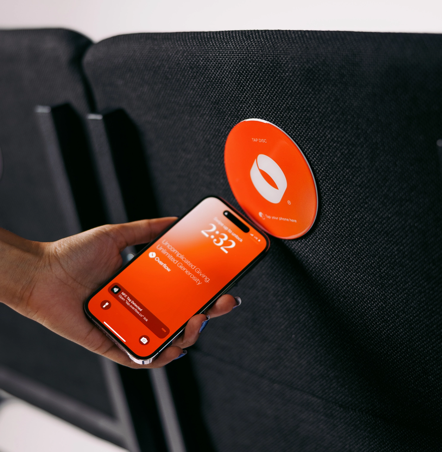 woman tapping her phone against an Overflow Tap Disc