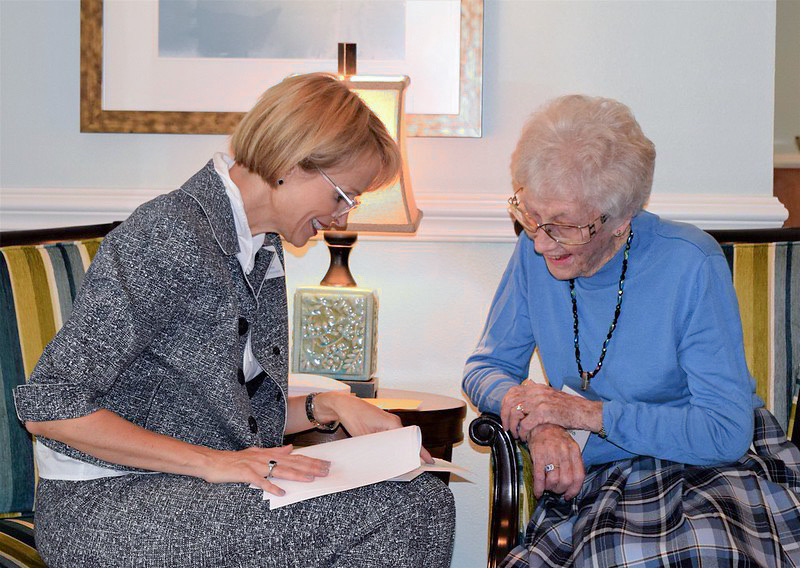 Two senior women sitting and discussing some documents