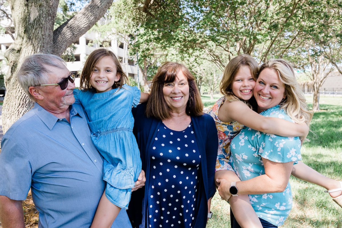 Family of three adults and two children smiling