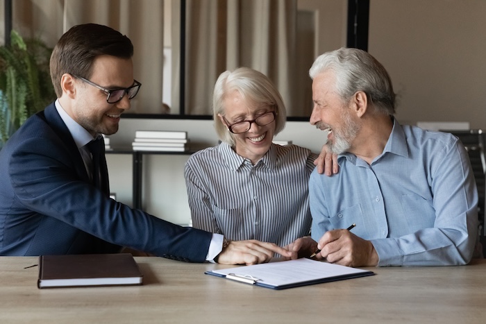 Senior couple reviewing financial documents with their financial advisor.
