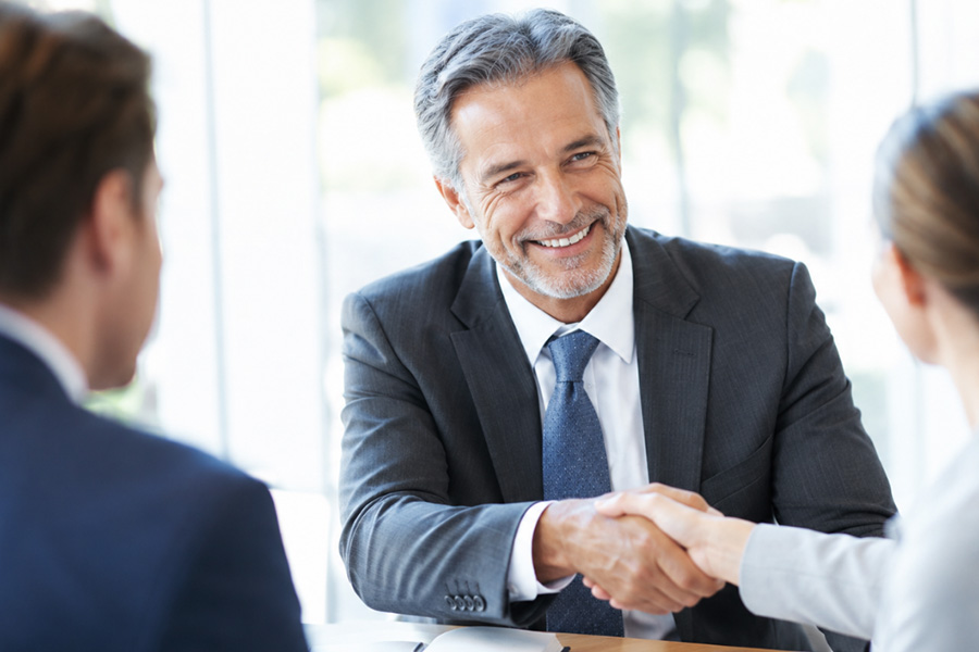 Man and woman sitting at conference room table discussing documents