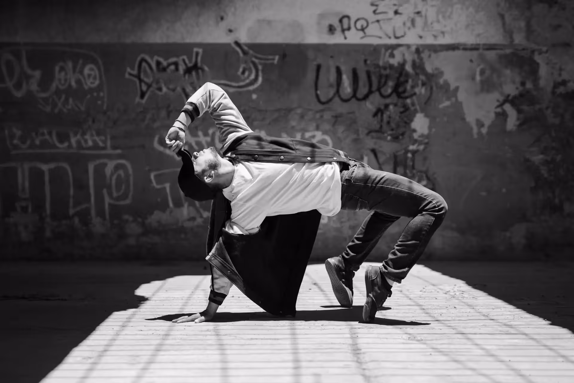 Un danseur fait un pont à une main au centre de l'image