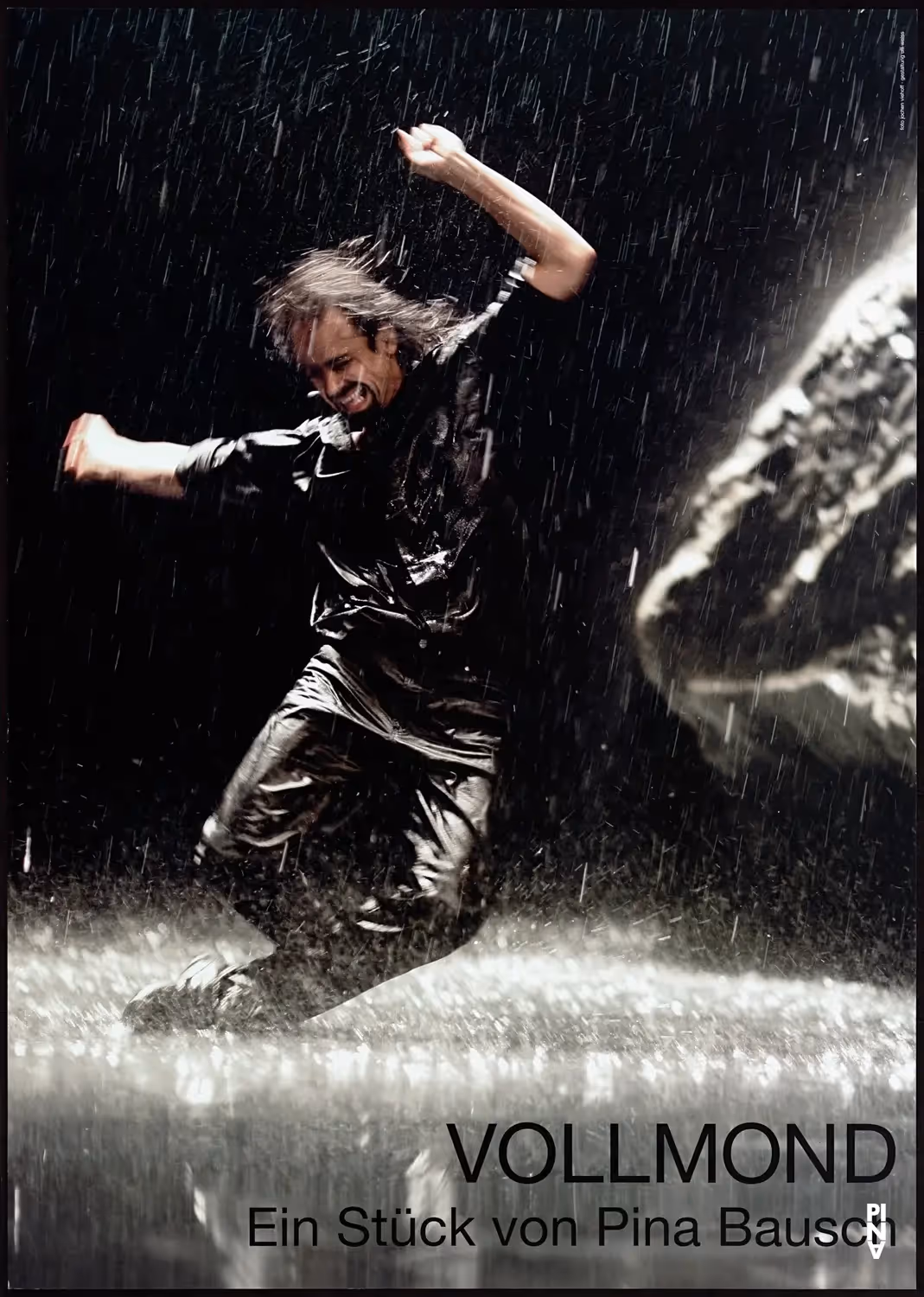 Affiche en noir et blanc du spectacle Vollmond. Sur scène, un danseur en mouvement sous une pluie battante.