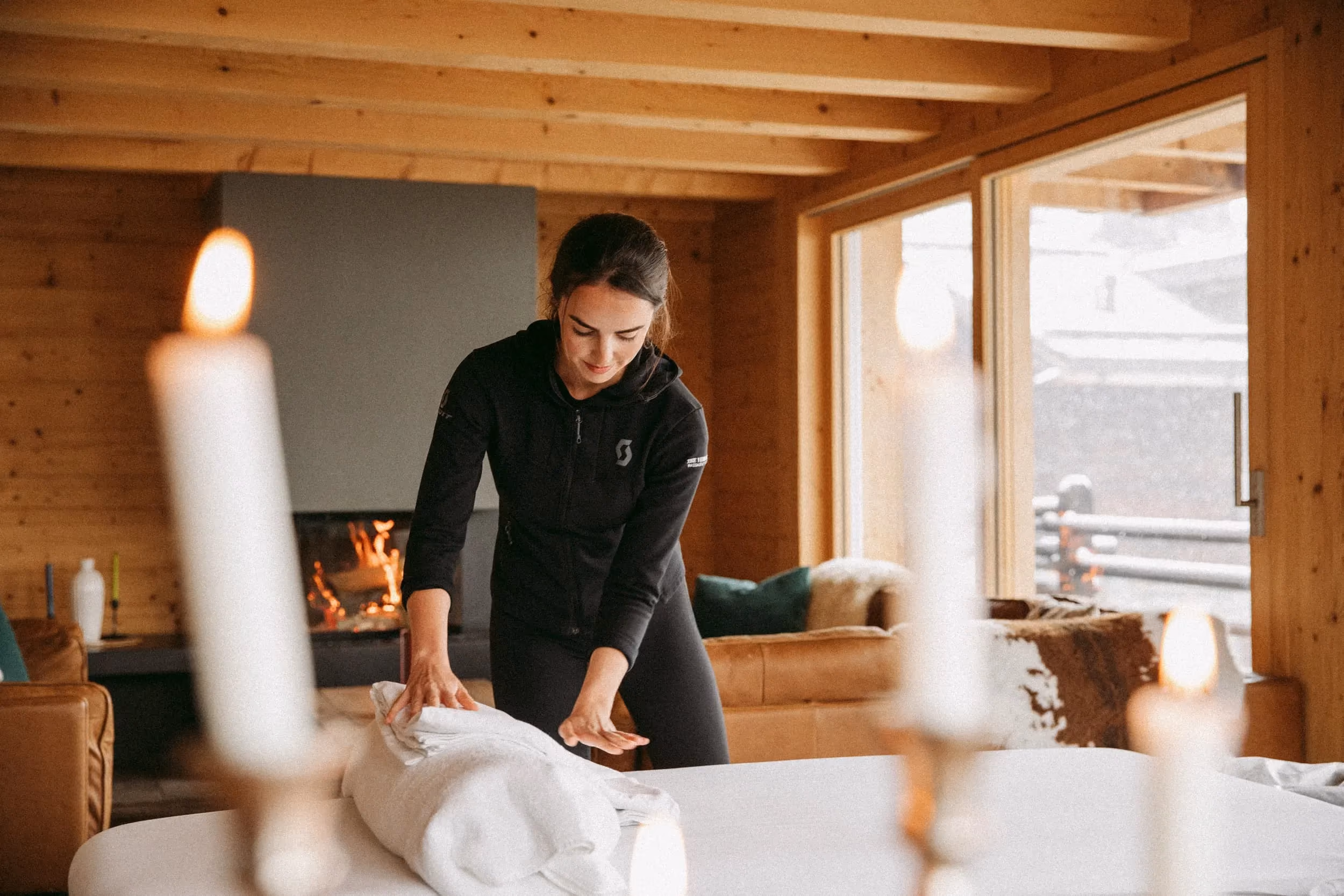A massage therapist preparing a treatment in a luxury hosted ski chalet in the Alps, arranged through the Armadillo concierge