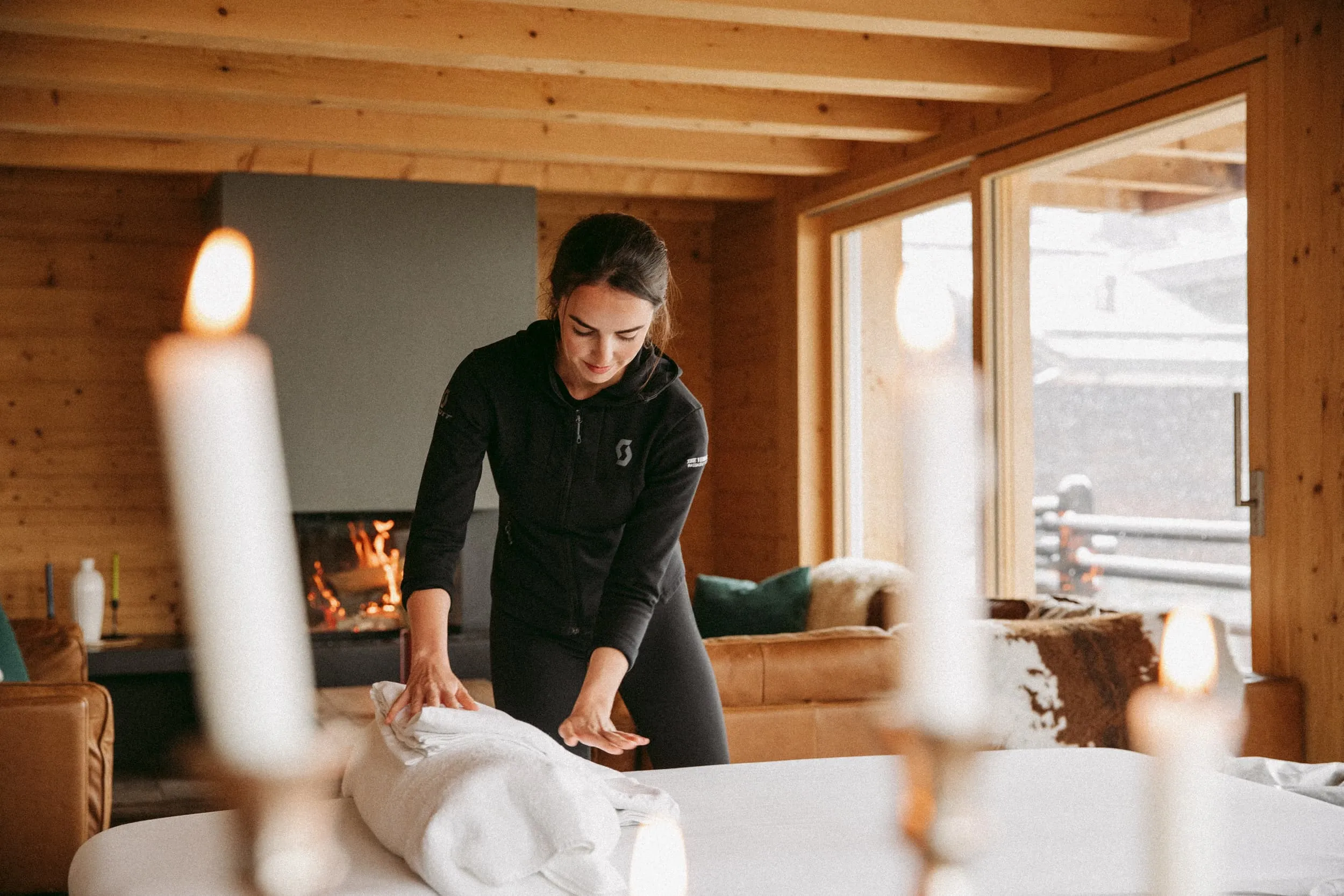 A massage therapist preparing a treatment in a luxury hosted ski chalet in the Alps, arranged through the Armadillo concierge