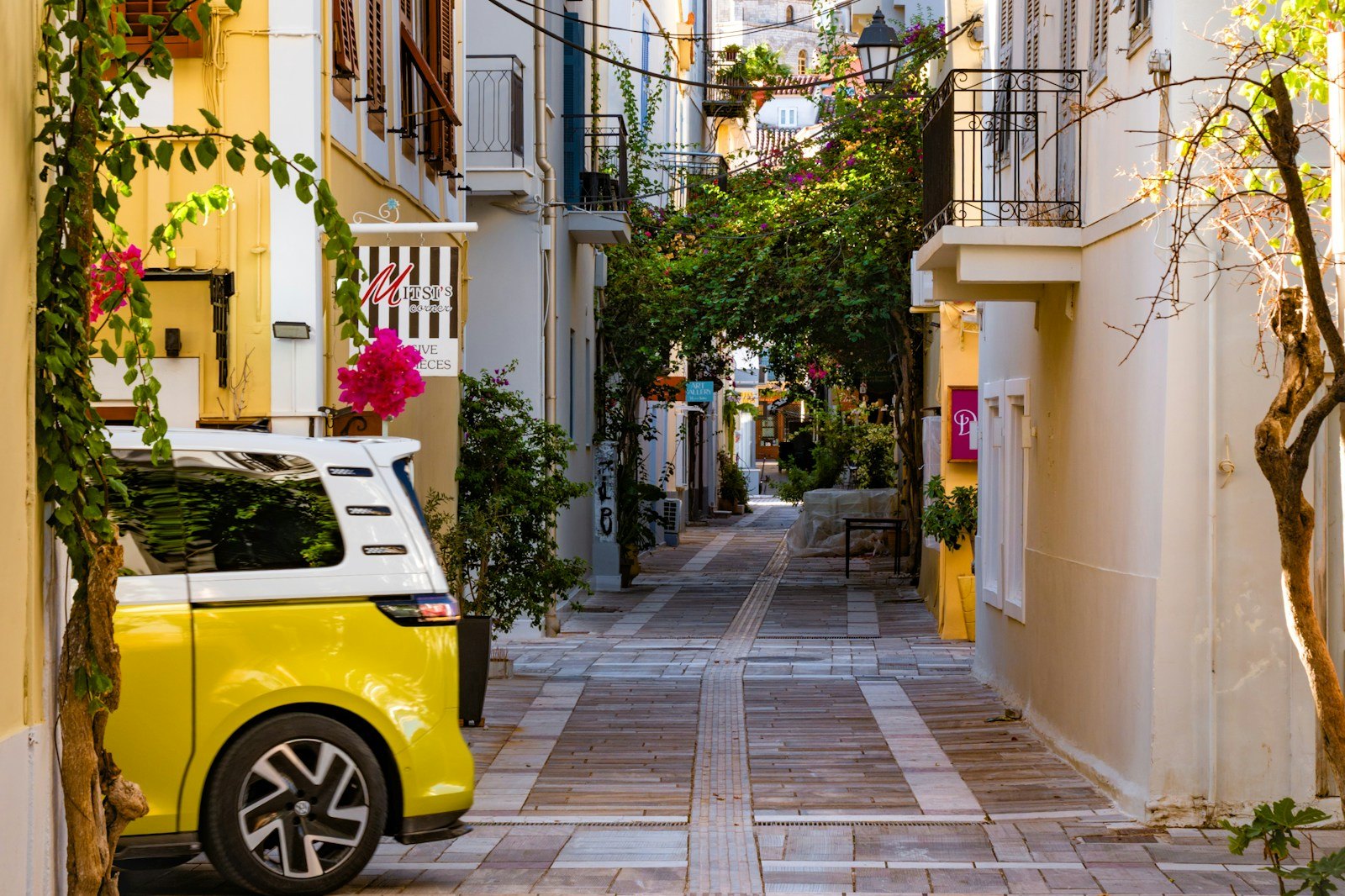 Κίτρινο αυτοκίνητο σε πλακόστρωτο στενό στην παλιά πόλη του Ναυπλίου