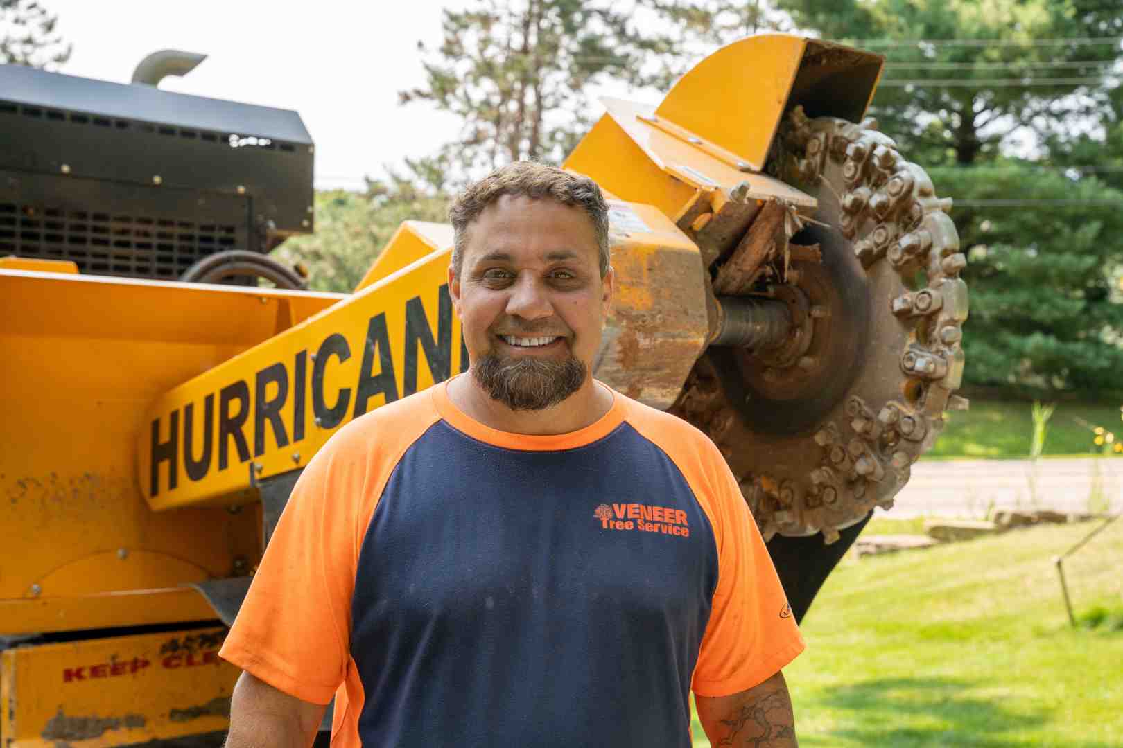 certified arborist safely operating a large stump grinder - stump grindering