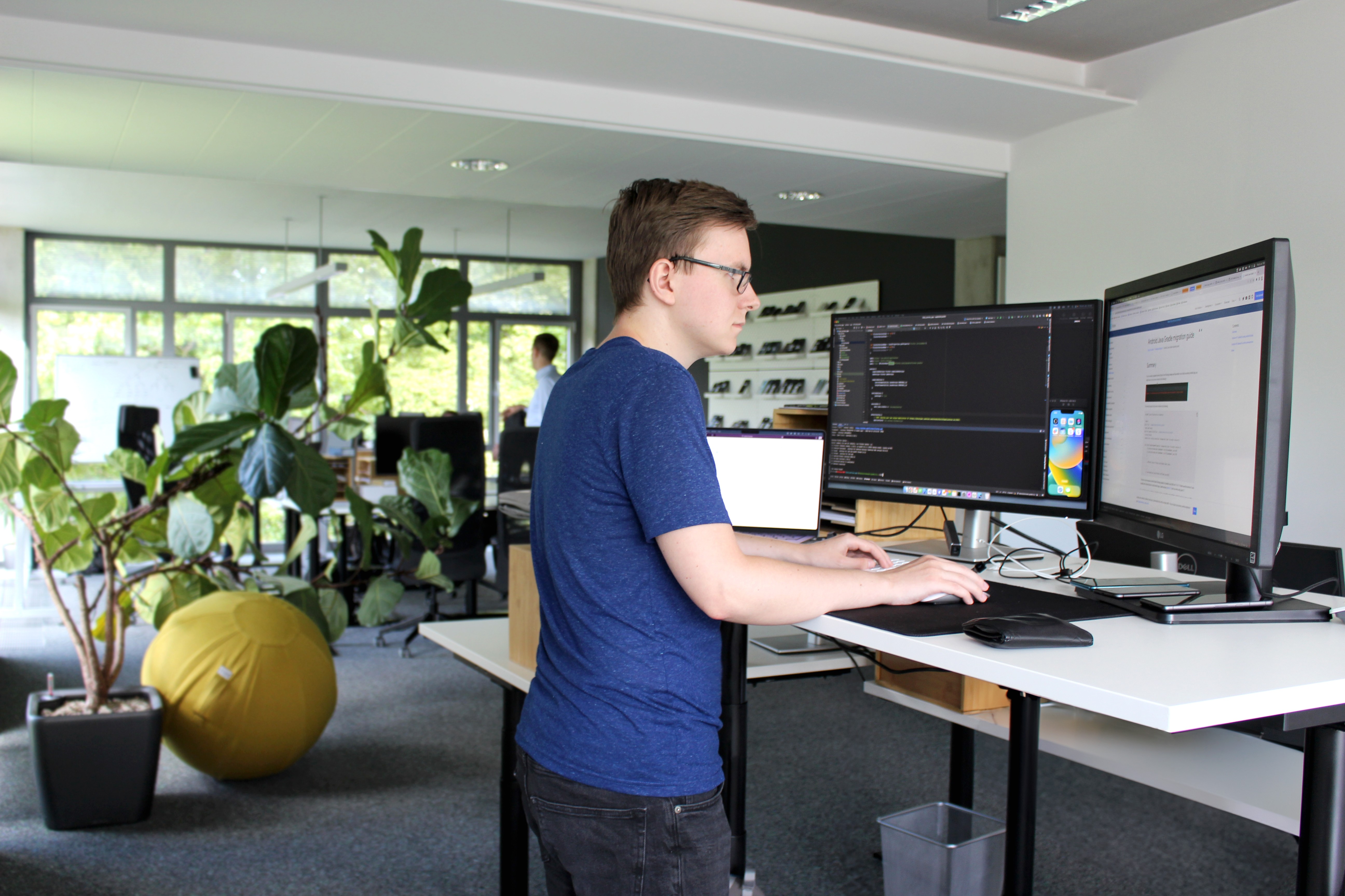 Employee standing by desk and working with computer