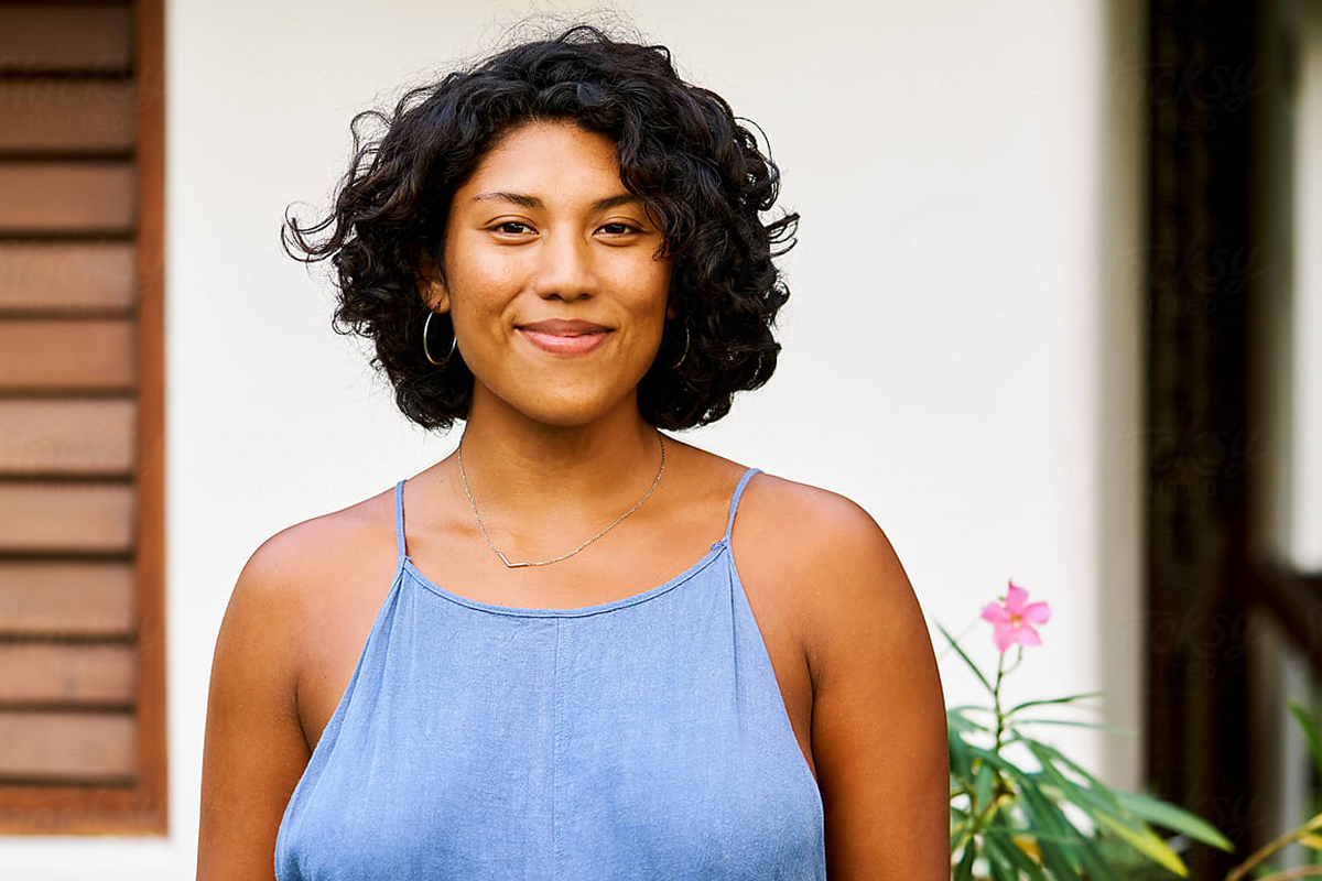 A smiling woman with short black curly hair