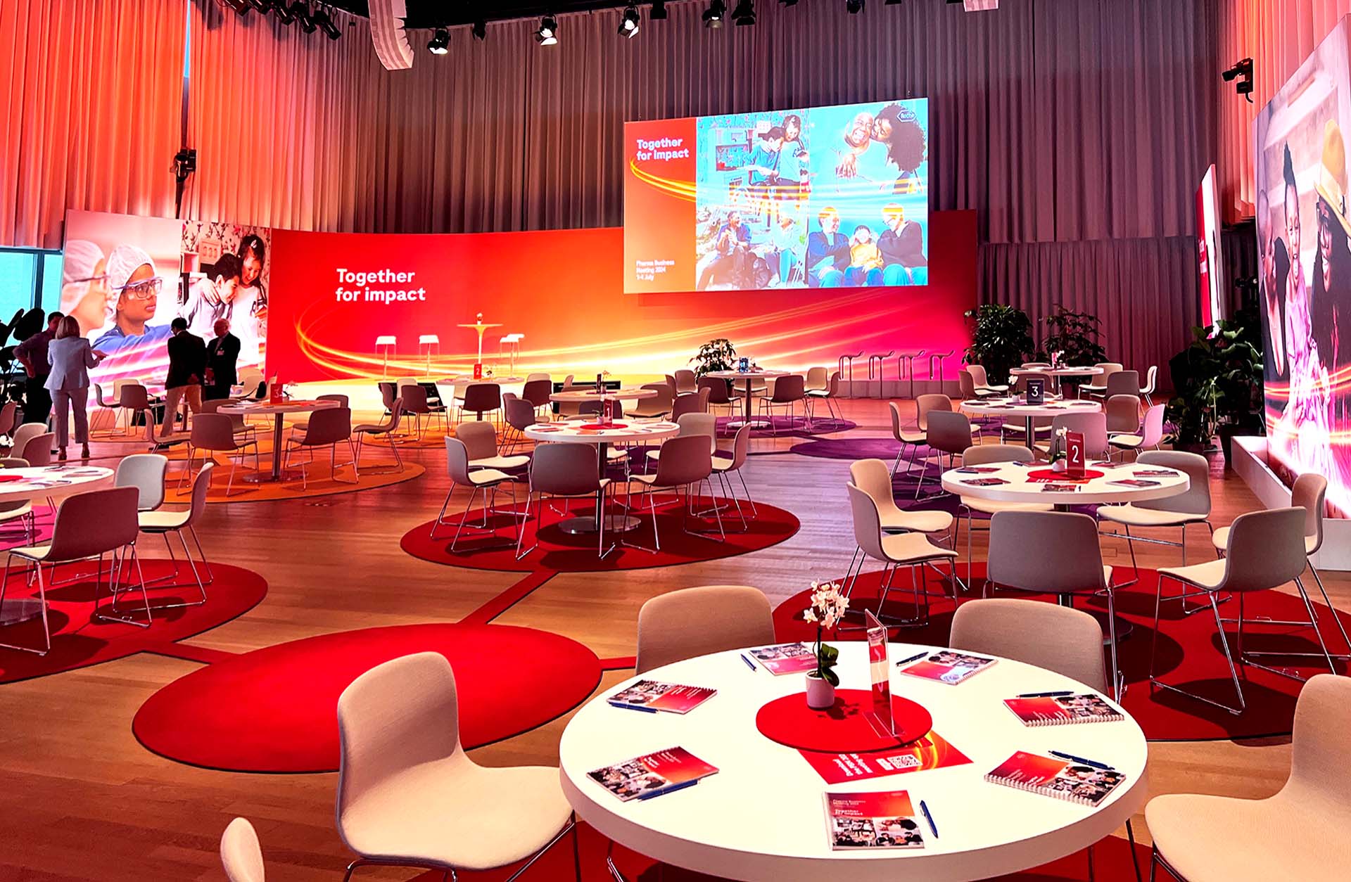 Bold meeting room setup with coloured carpets connecting group tables.
