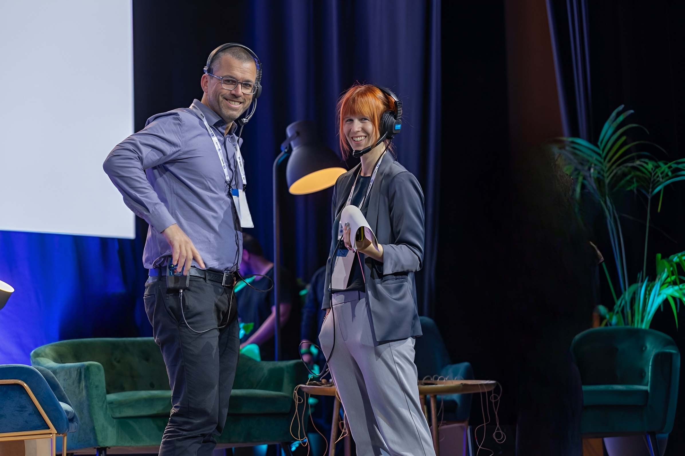 Managing Director and Event Producer onsite smiling at camera from edge of stage.