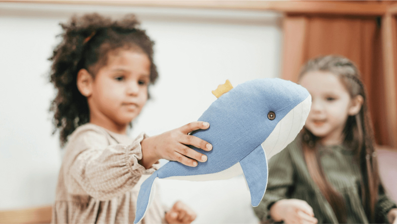 two little girls playing with soft toys 