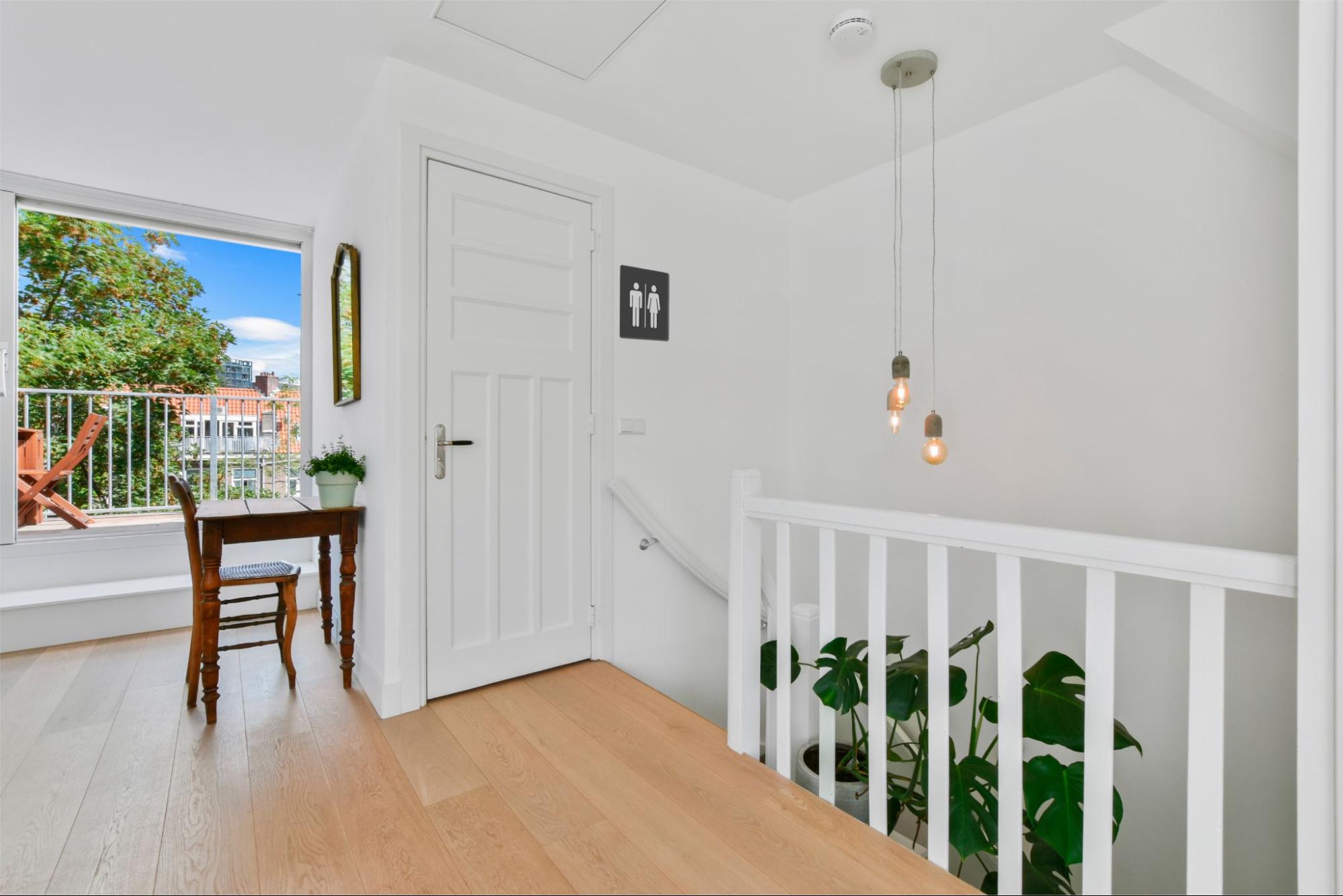 An all-white interior of the second floor with a bathroom.