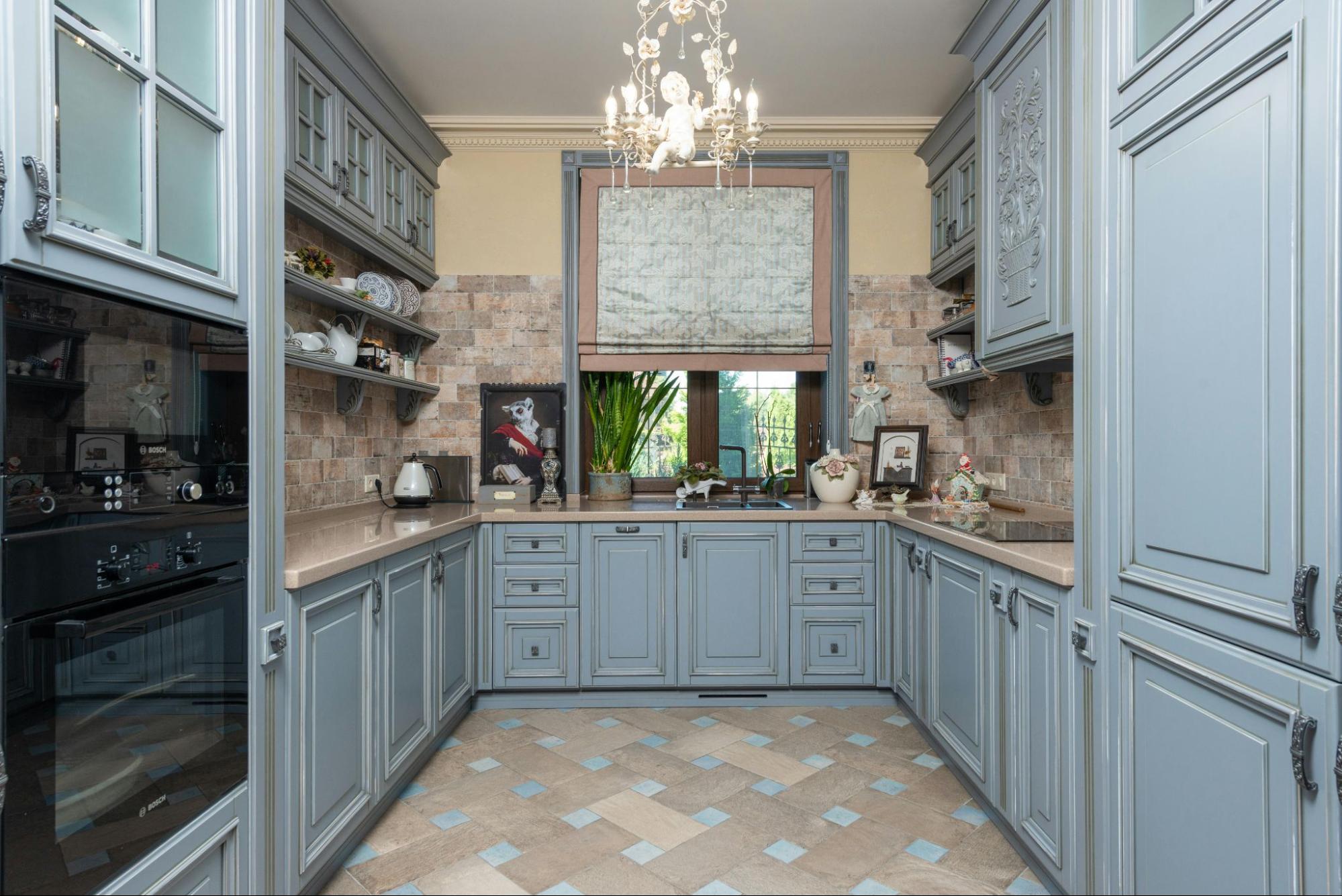 A powder blue painted kitchen with lots of cabinets.