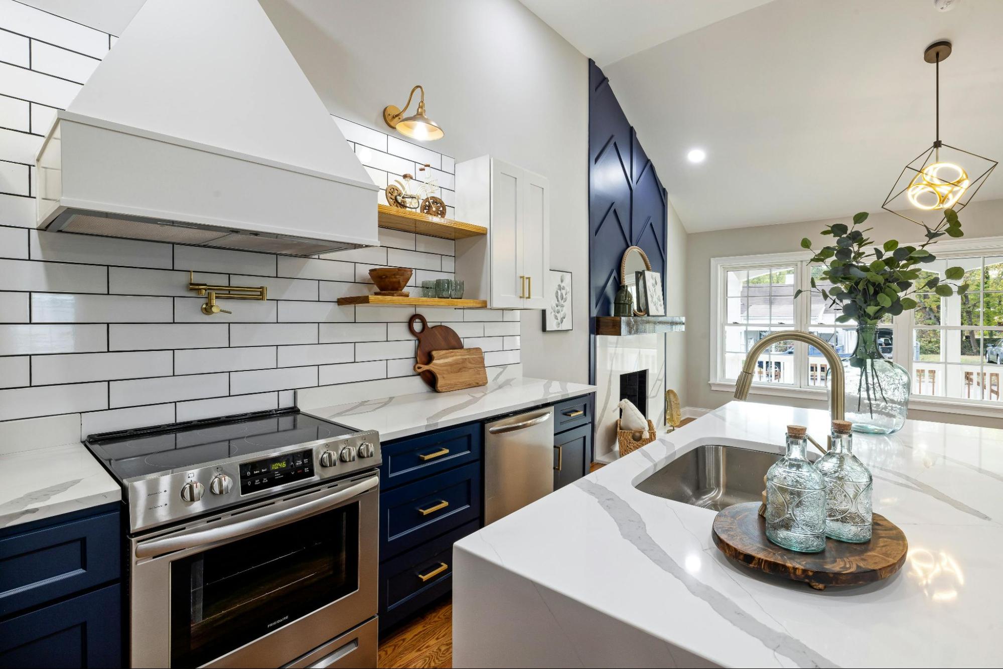 A small blue and white kitchen with cabinets, stove, and a basin.