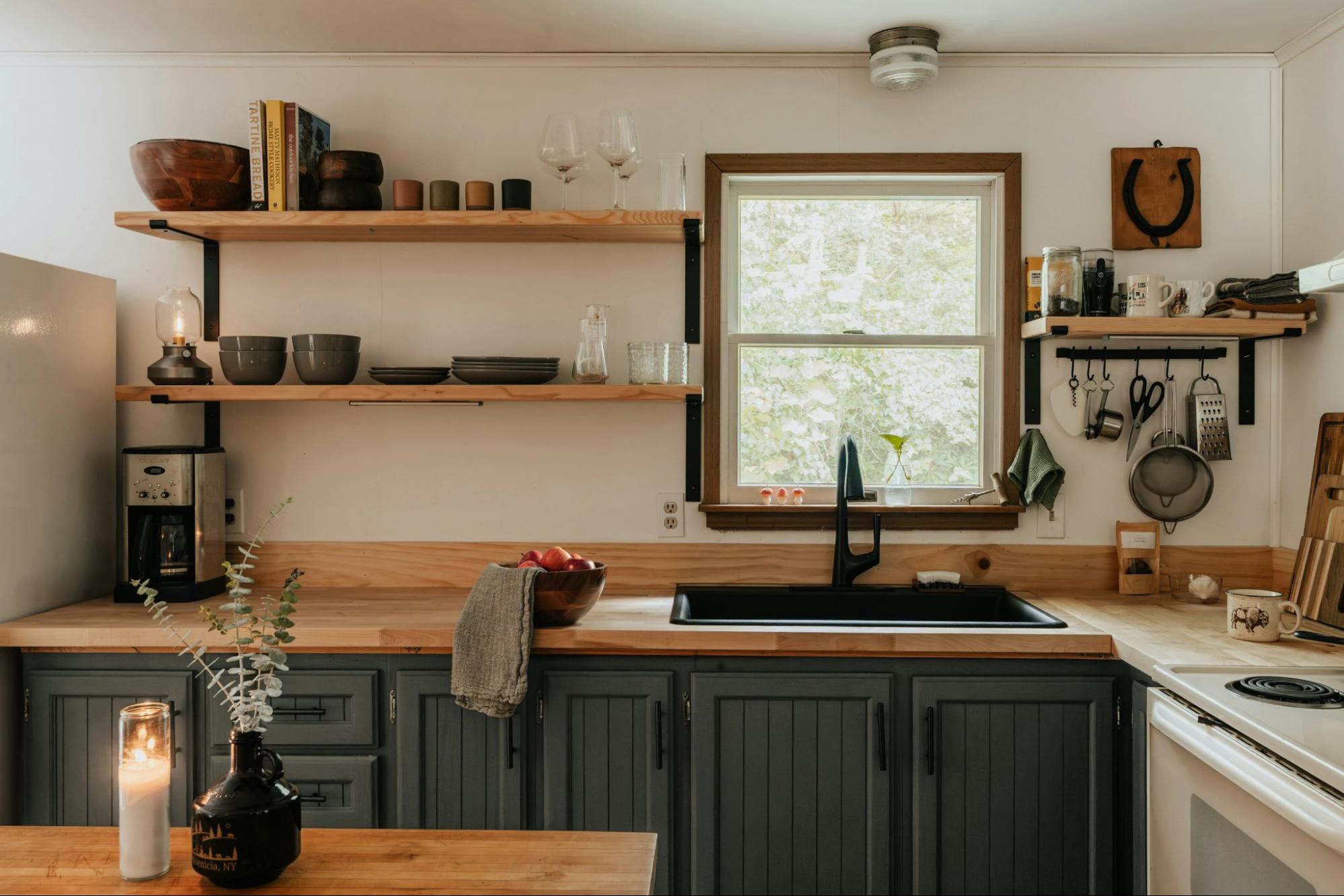 A small, modern kitchen with floating shelves.