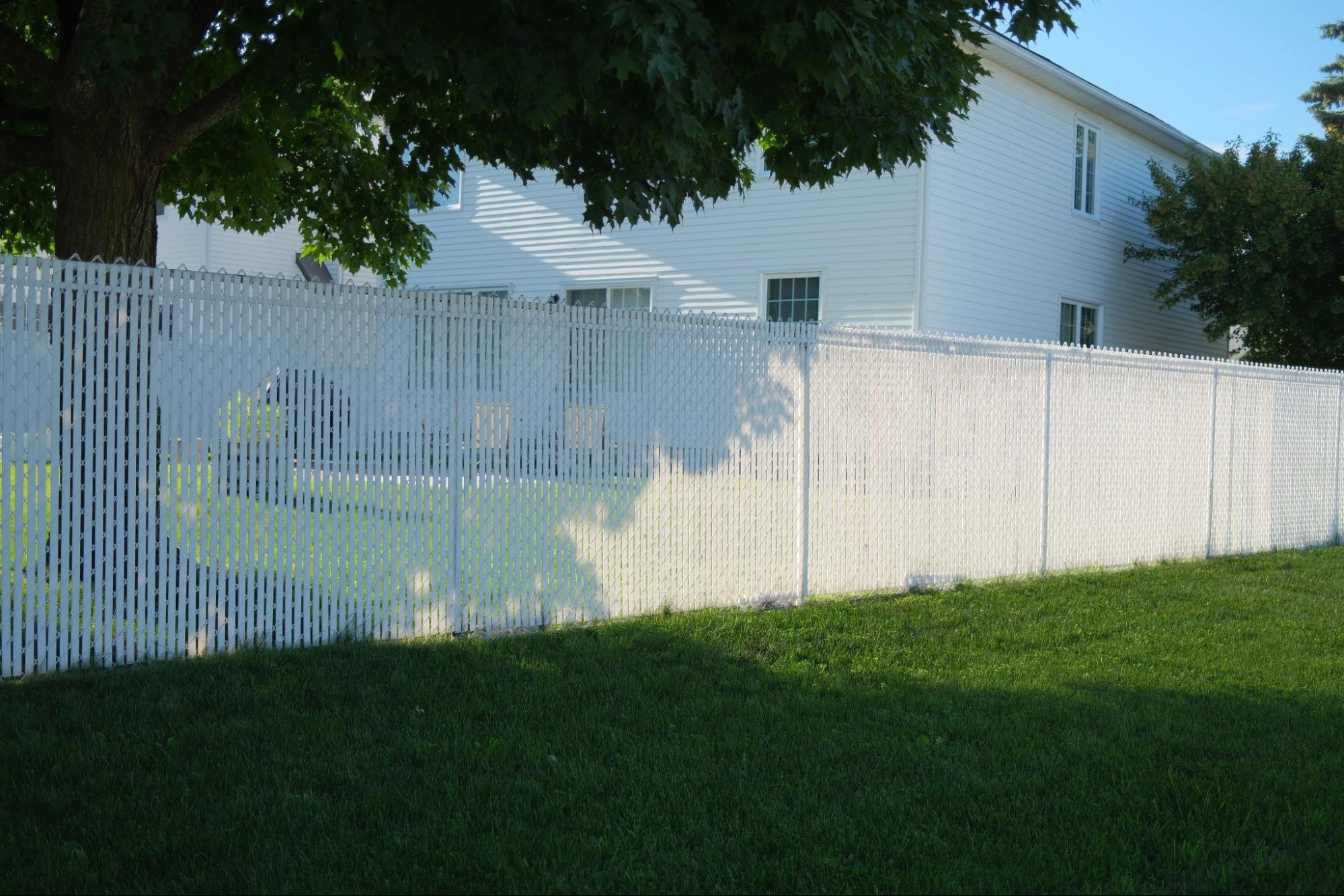 Long, white privacy fence panels in backyard.