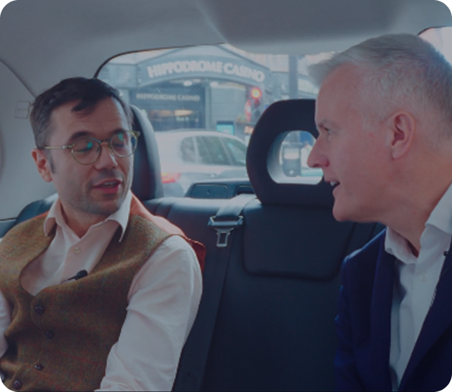 Two GX guests in conversation in the back of a London taxi