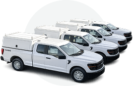 Fleet of five white pickup trucks parked in a staggered row.
