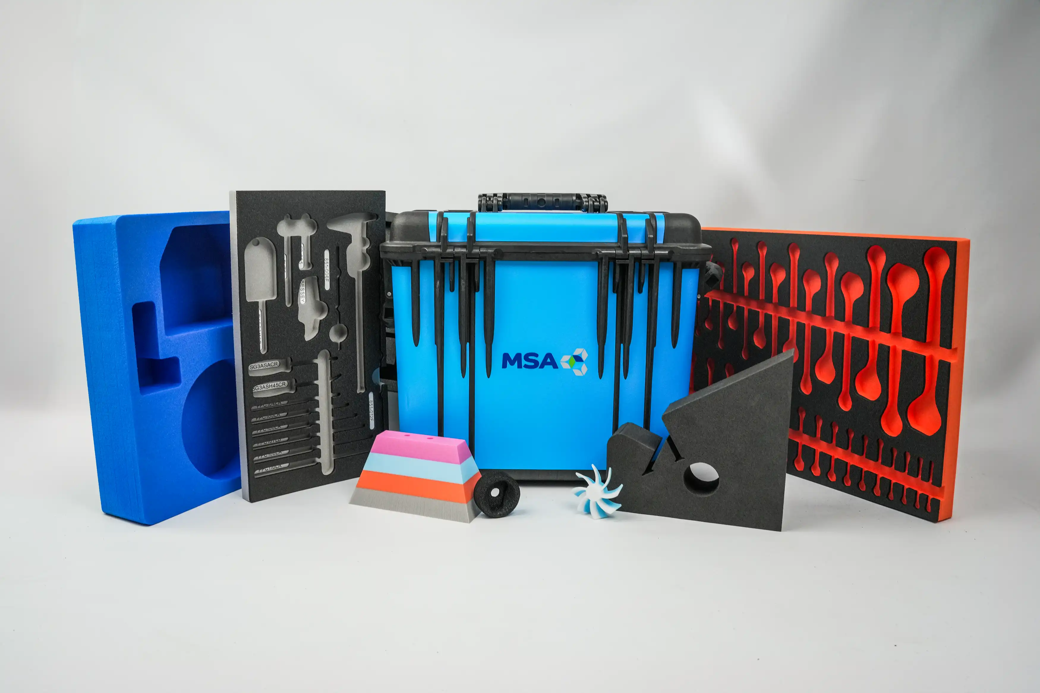 A wrapped blue 1440 Peli Protector case, two custom foam inserts for tool control and various cut foam shapes to showcase MSA Foams' capabilities.