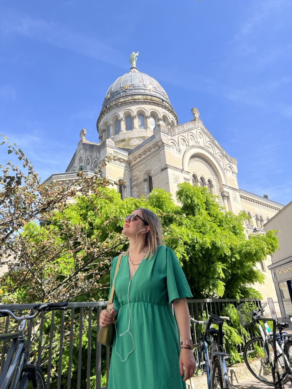 Une femme visite la ville en écoutant un audioguide à l'aide de ses écouteurs