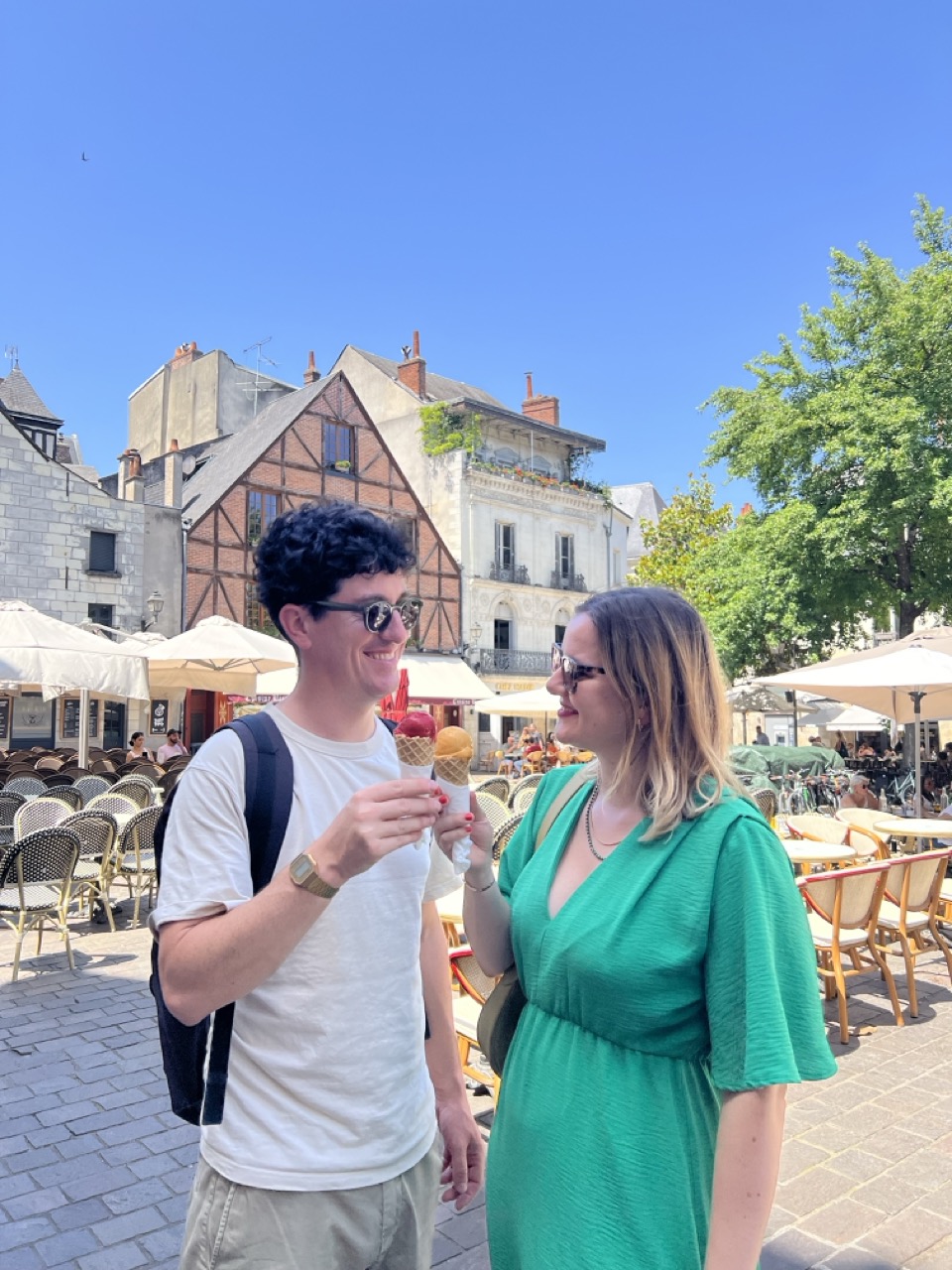 A cute couple enjoying an ice cream in a historic square