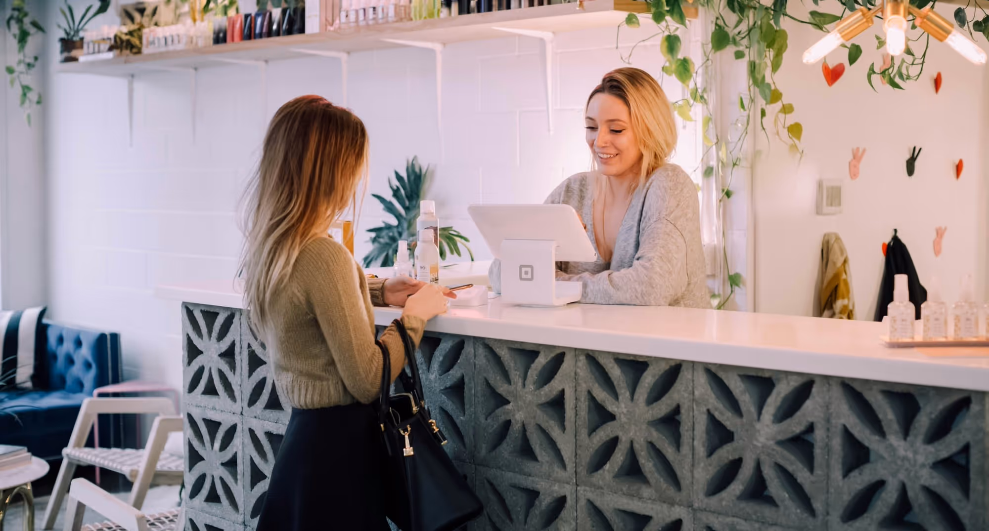 A woman paying at the till in a shop.