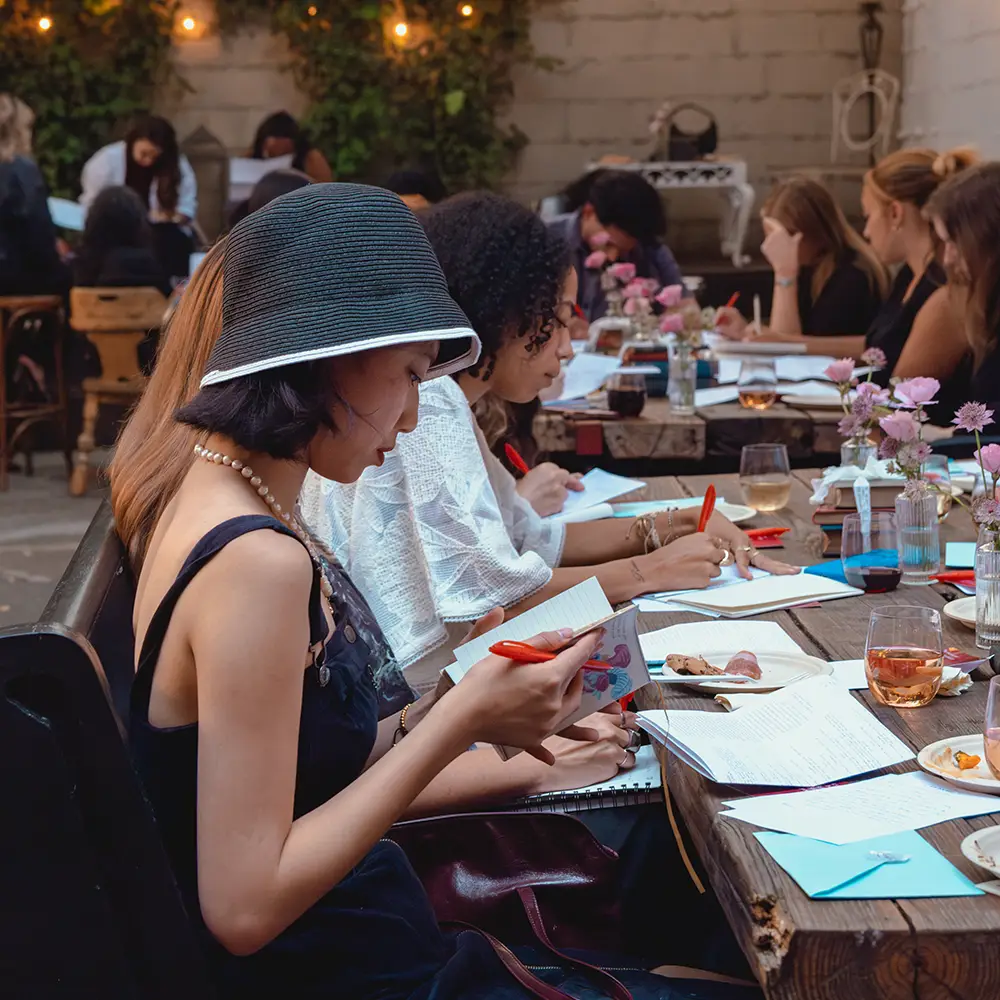 A woman writing in a journal at a Writing Salon