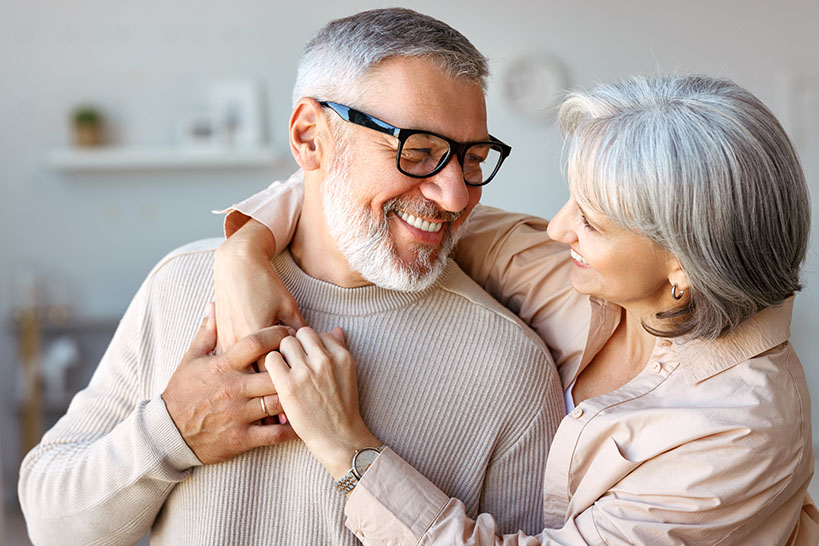 A happy couple, hugging and smiling 