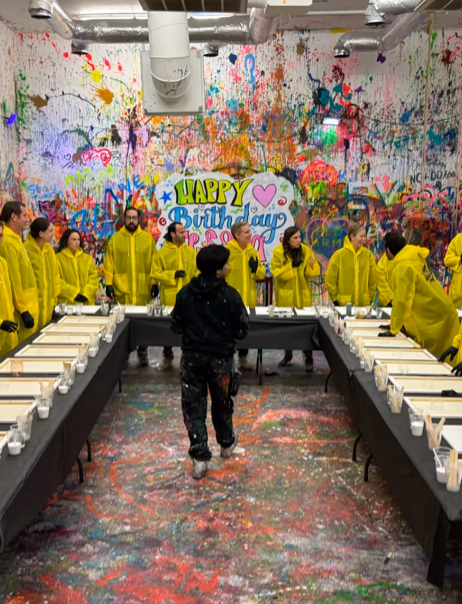 Large birthday workshop setup with guests in ponchos