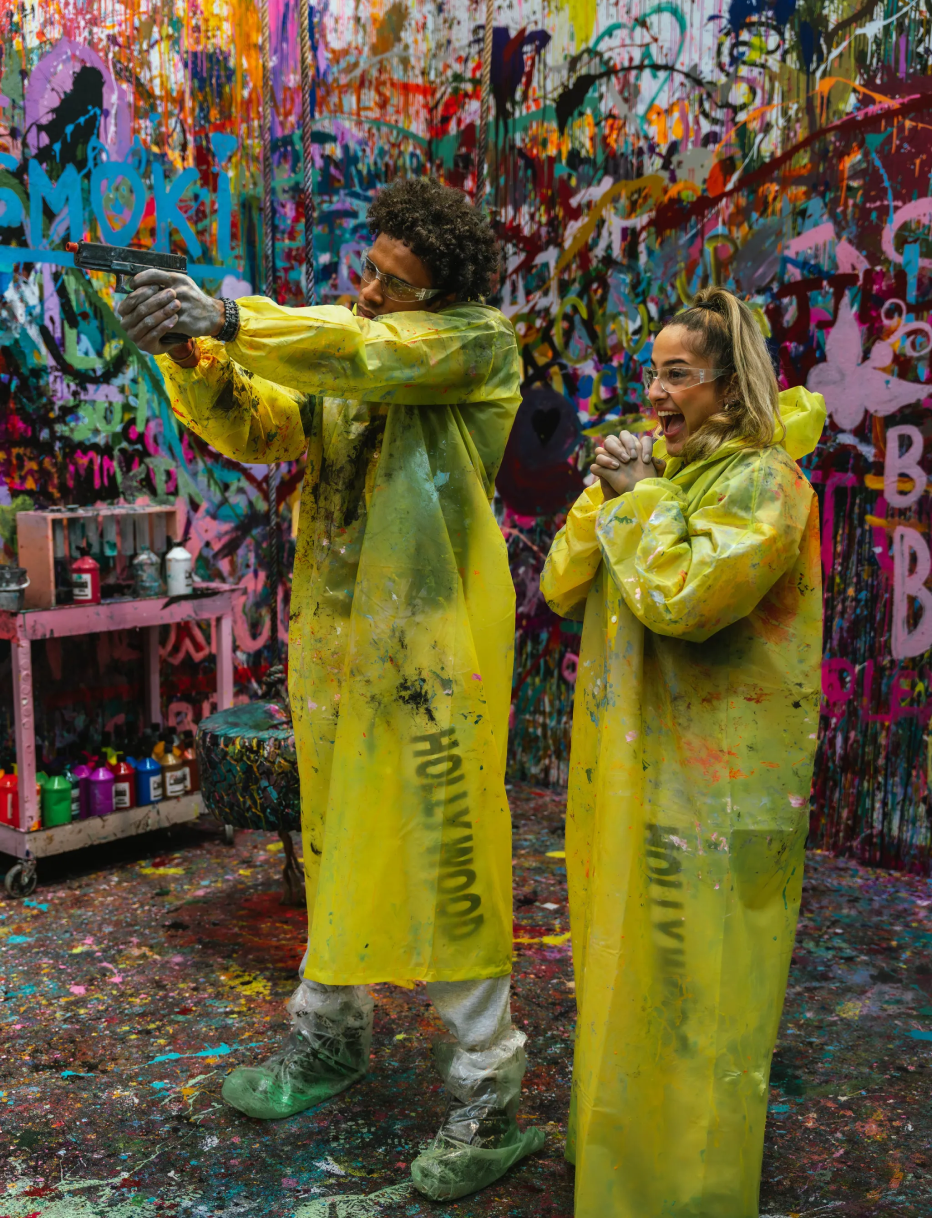 Couple aiming the paint blaster and laughing during date night