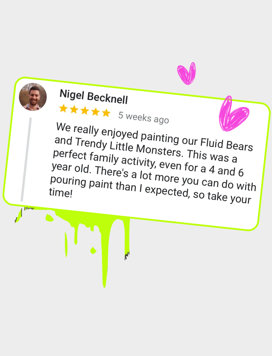 Child smiling while holding a paint blaster in the splatter room