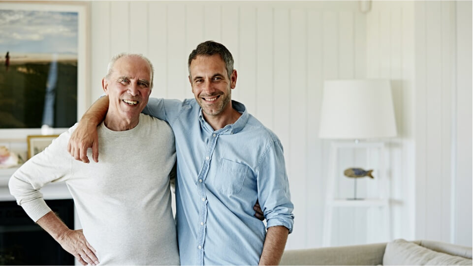 Father and son arms around each other in the living room.,