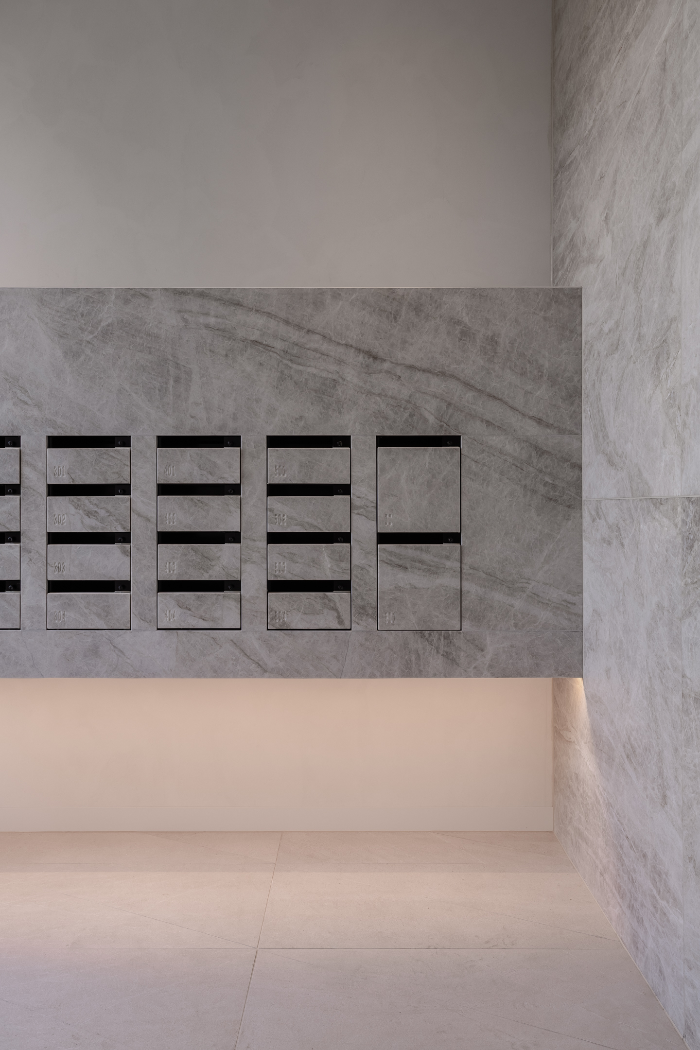 A sleek and modern butler's pantry featuring ample storage space, illuminated shelving and a seamless countertop with integrated sink, flowing into an elegant open-plan living area.
