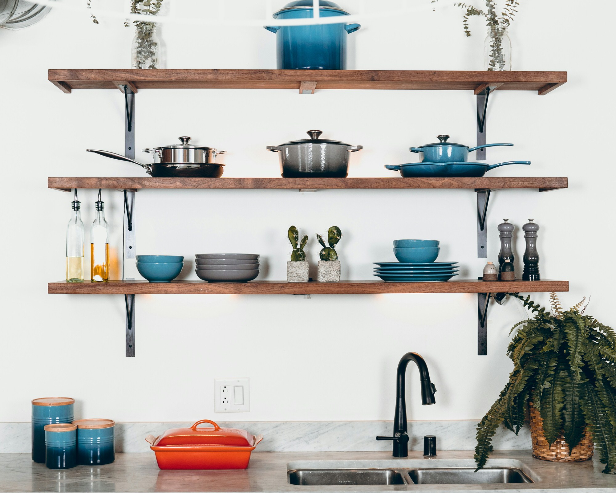 Domestic kitchen shelves with plates, bowls, and jars of oil.