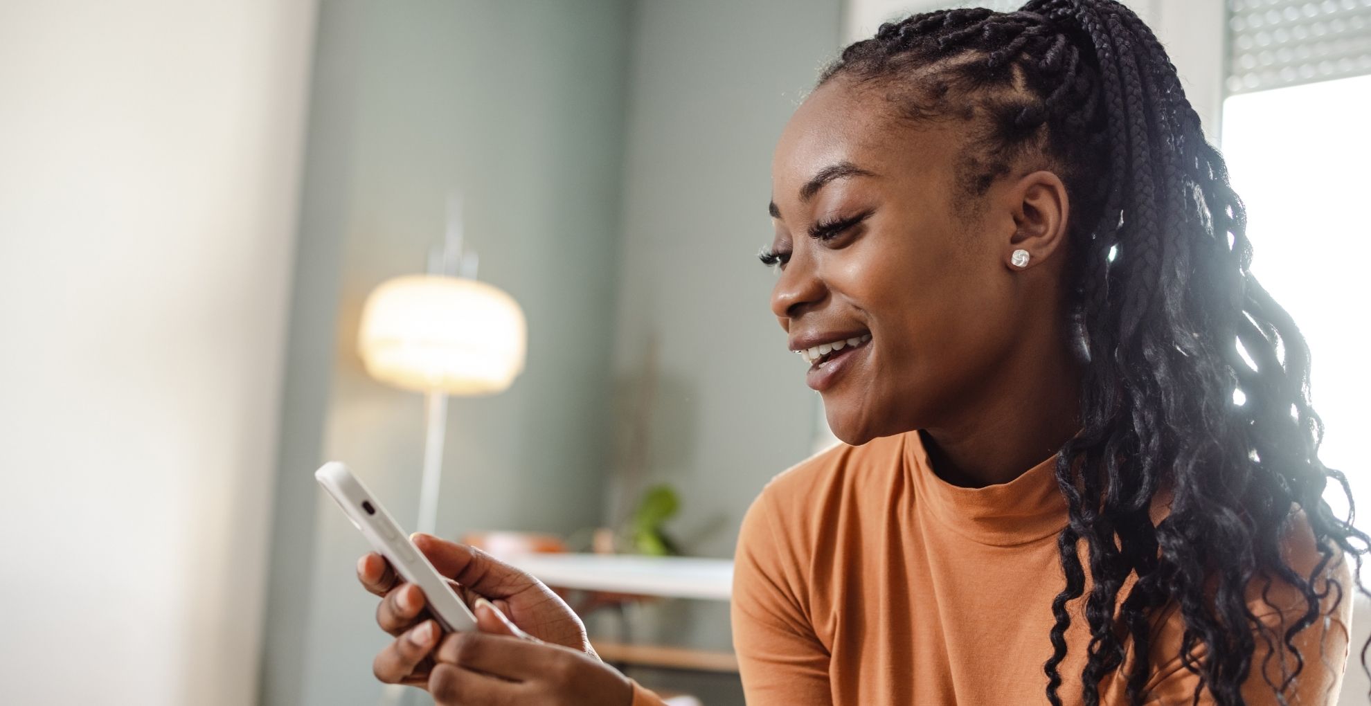 Vrouw met telefoon in haar hand en kijkt daarop