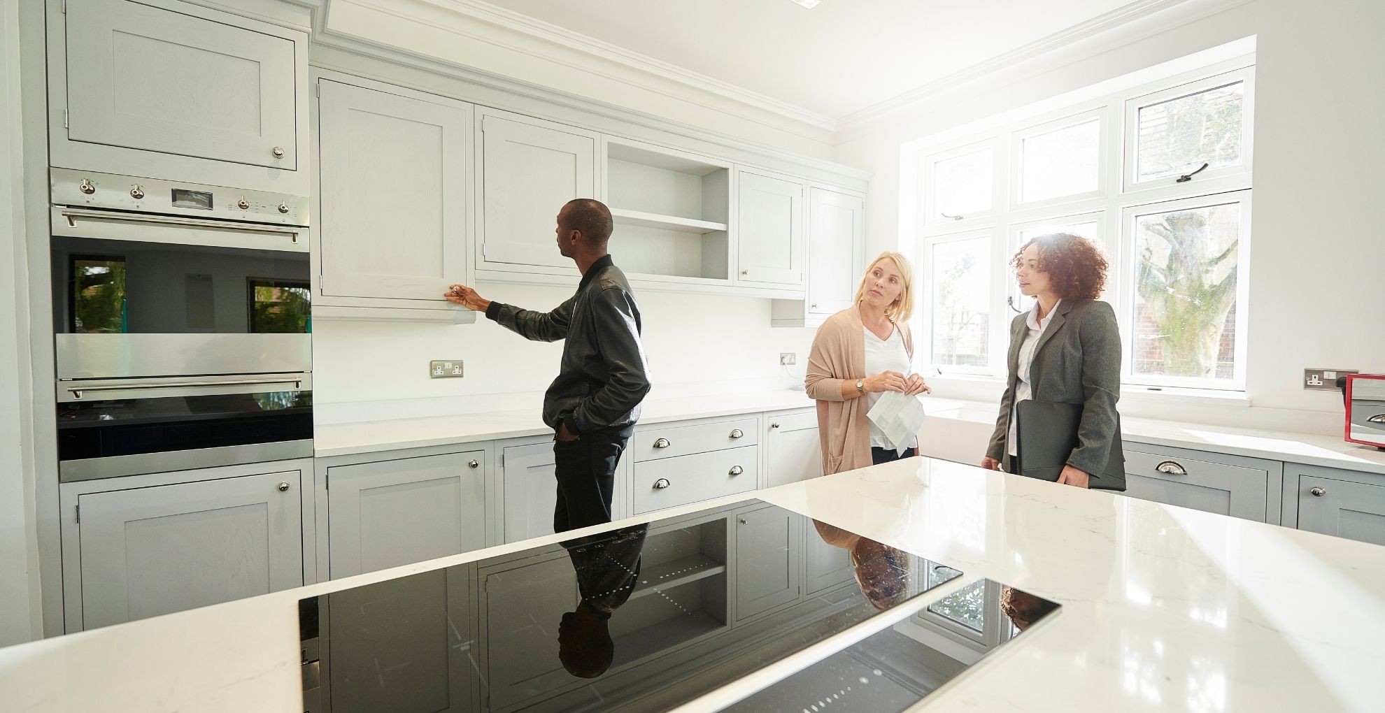 Man en vrouw bekijken keuken met makelaar