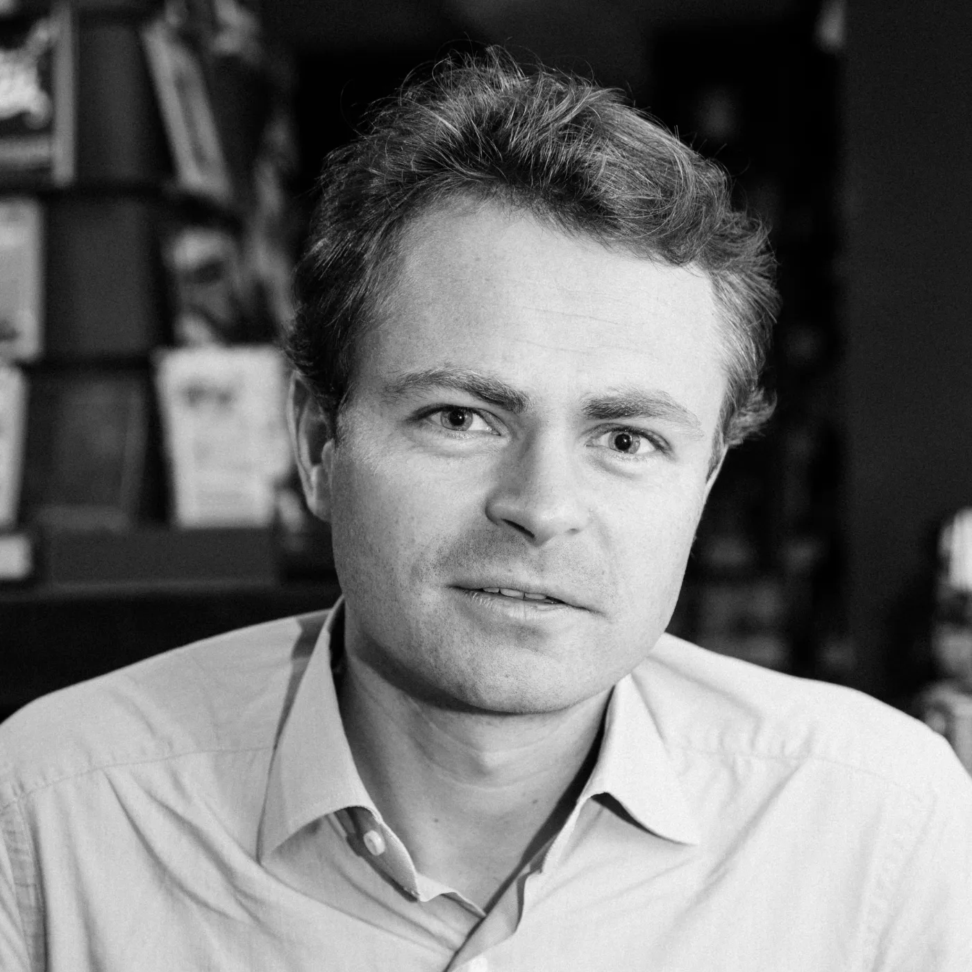 A black and white photo of a man in a shirt.