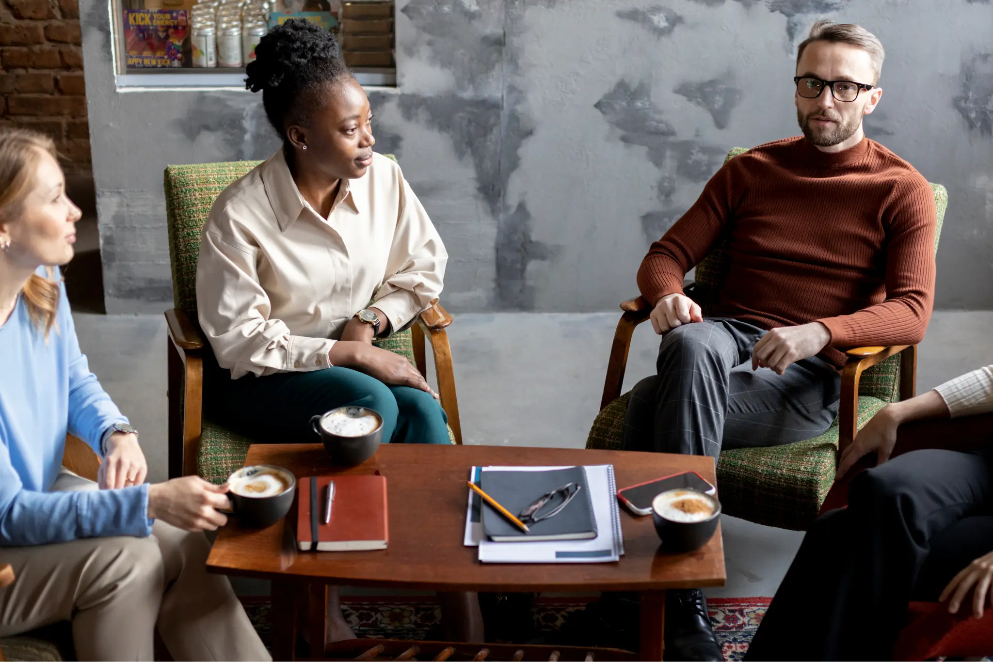 StoryTerrace - Books That Matter - Three people sitting around a coffee table, engaged in conversation.