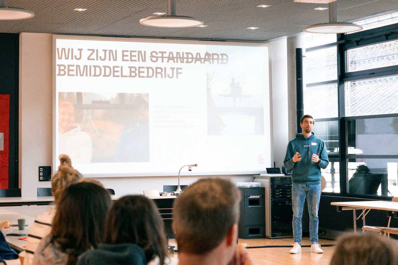 Präsentation für Physiotherapeuten an einem takeoff-Event mit der Folie 'Wij zijn een standaard bemiddelbedrijf', auf der 'standaard' durchgestrichen ist