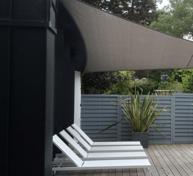 Patio moderne avec chaise longue et voile d'ombrage pour un moment de détente
