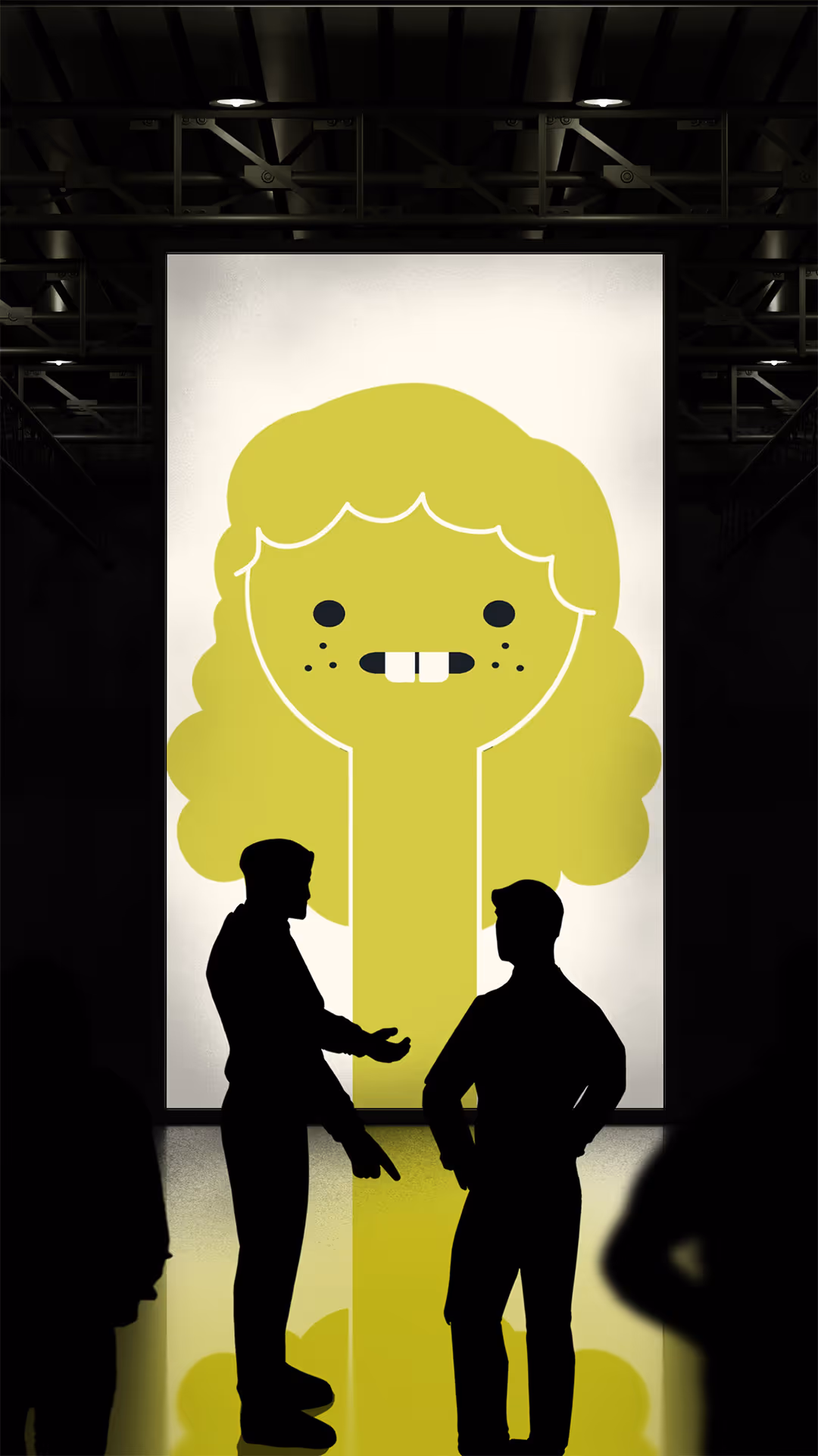 Silhouettes of two people talking in front of a large cartoonish green face poster in a dark room.