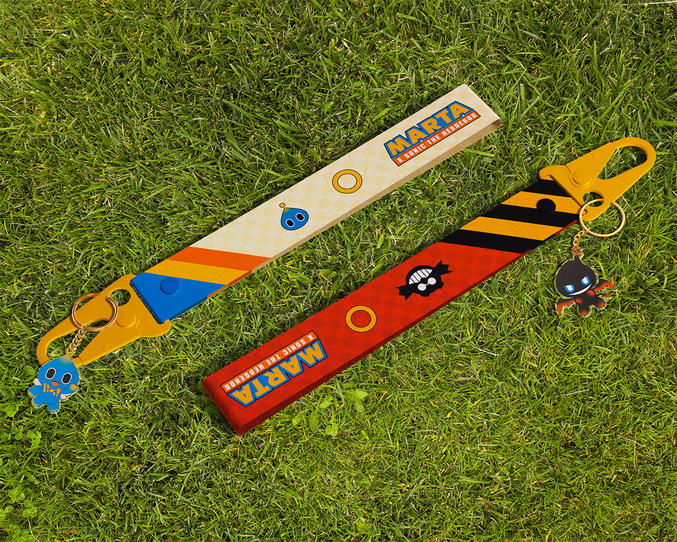 Two colorful short lanyard keychains with MARTA x Sonic the Hedgehog branding on grass.