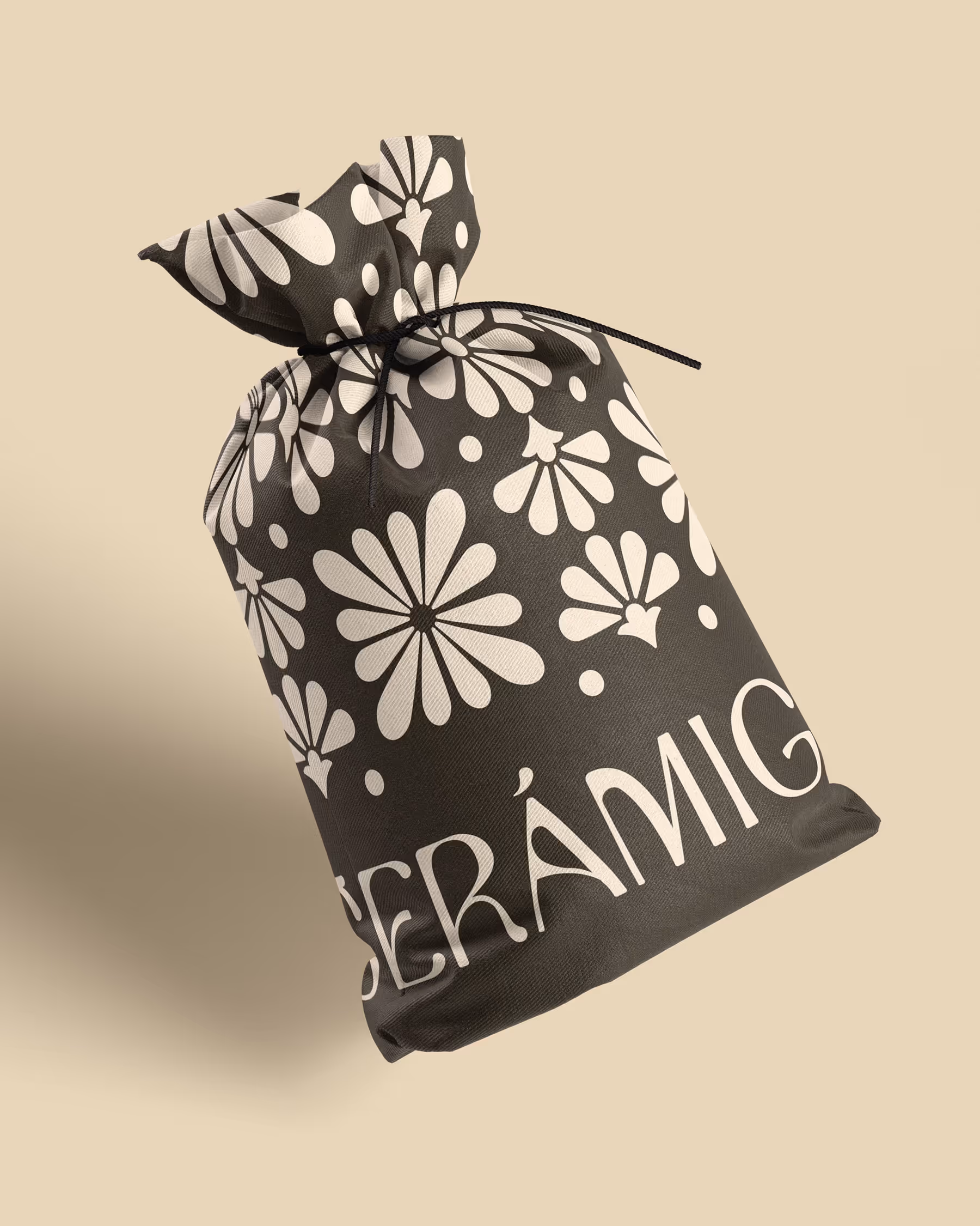 Black drawstring bag with white floral patterns and the word 'CERAMIGA' in bold letters.