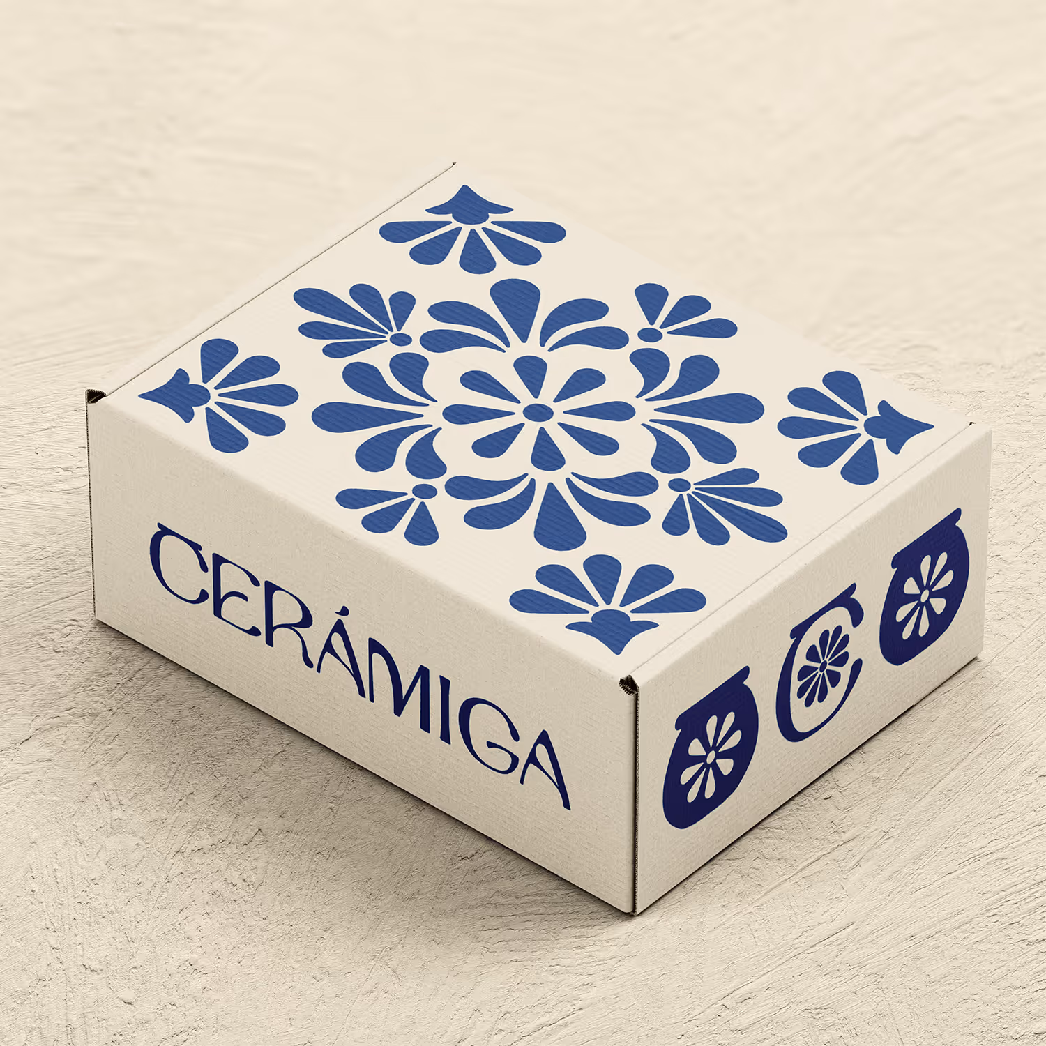 Cardboard box with blue floral patterns and text 'CERÁMIGA' on a textured surface.