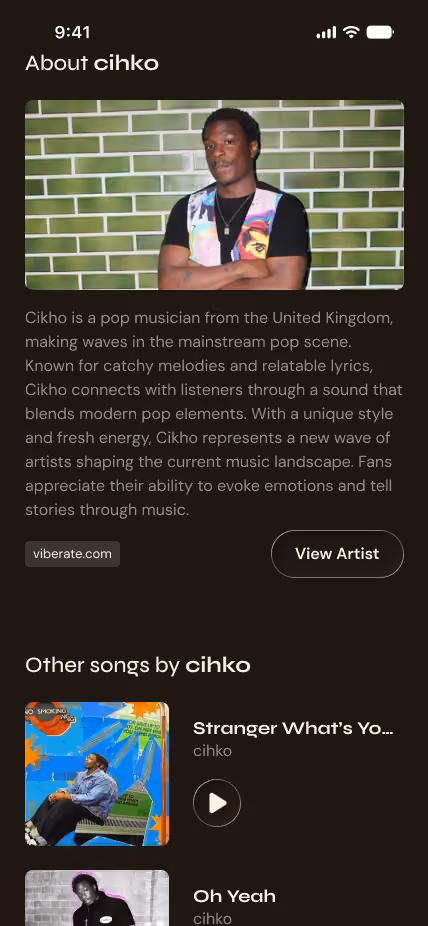 Profile of pop musician Cihko standing with arms crossed wearing colorful vest against a green brick wall.