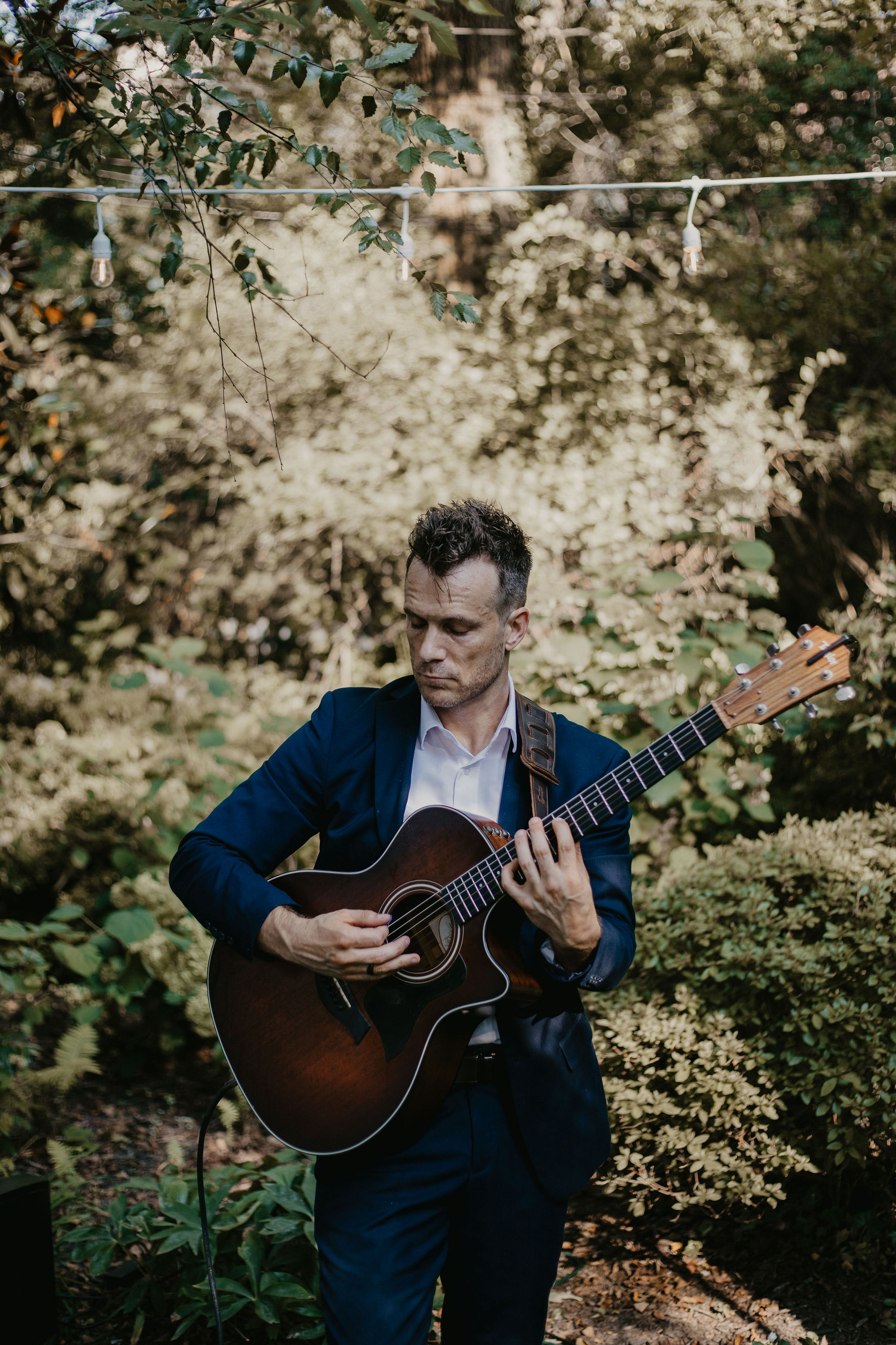 Dylan Galvin playing live acoustic guitar at an outdoor wedding ceremony in the DMV