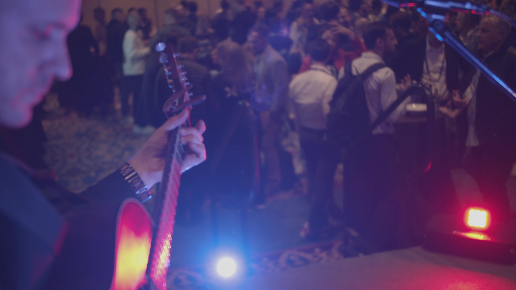 Dylan Galvin performing live on acoustic guitar among guests at an upscale hotel event