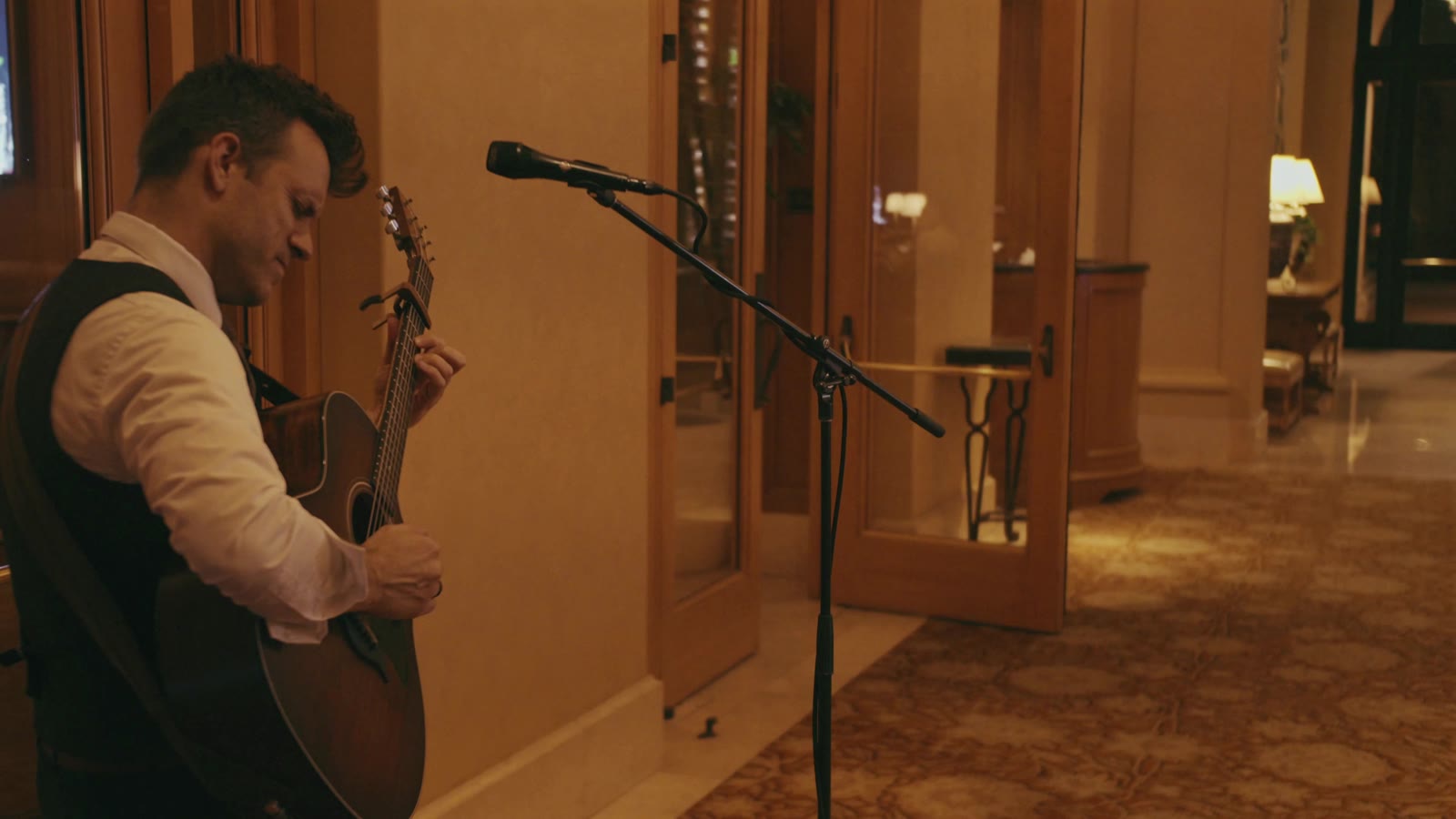 Dylan Galvin performing acoustic guitar mid-song at a private event at Pelican Hill Resort in California.
