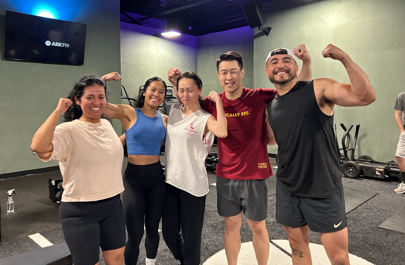 Smiling Ark Fit members flexing together after a group class